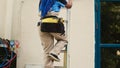 HVAC specialist climbing folding ladder