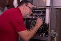 HVAC Technician Adjusting A Gas Furnace