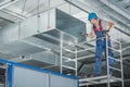 HVAC Technician Testing Newly Installed Warehouse Ventilation System Royalty Free Stock Photo