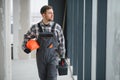 Hvac technician walking in building under construction carrying tools and helmet Royalty Free Stock Photo