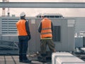 HVAC Technicians Inspecting Industrial Air Conditioning Unit