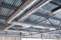 HVAC. Ventilation pipes in silver insulation material hanging from the ceiling inside new building. Royalty Free Stock Photo