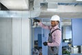 hvac african worker install ducted pipe system for ventilation and air conditioning. copy space Royalty Free Stock Photo