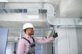 hvac african worker install ducted pipe system for ventilation and air conditioning. copy space Royalty Free Stock Photo