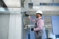 hvac african worker install ducted pipe system for ventilation and air conditioning. copy space Royalty Free Stock Photo