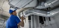 Hvac worker install ducted pipe system for ventilation and air conditioning. copy space Royalty Free Stock Photo