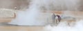 People standing near a steaming fumarole in geothermal area of Hverir, Iceland