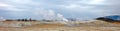 People standing near a steaming fumarole in geothermal area of Hverir, Iceland