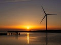Hvide Sande canal with wind turbine and jetty at sunset over North Sea, Mid Jutland, Denmark