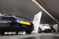 Hybrid car at charging station in underground parking with power supply point