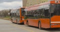 Hybrid city buses standing at a temporary stop.