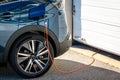 A hybrid electric car plugged in at home Royalty Free Stock Photo