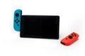 Hybrid video game console with switch detachable controllers on both sides. The left gamepad is blue and the right one red