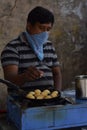 Hyderabad, Telangana, India. july-20-2020: indian street food maker preparing ponganaalu while wearing face mask, tasty food,