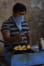 Hyderabad, Telangana, India. july-20-2020: indian street food maker preparing ponganaalu while wearing face mask, tasty food,