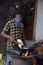 Hyderabad, Telangana, India. july-20-2020: indian young man preparing jilebi at street while wearing face mask, corona pandemic