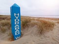 The Hydrabad shipwreck sign partially buried in sand