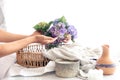 Hydrangea flowers in a vase in female hands on a light background. Royalty Free Stock Photo