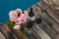Hydrangea two glasses and a bottle of red wine on the wooden floor near the pool Royalty Free Stock Photo