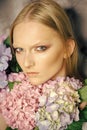 Hydrangeas in the beauty salon. Young beauty woman face with blond hair and hydrangea