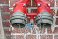 Hydrant with two taps for quick collection of water on a brick wall. Royalty Free Stock Photo