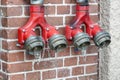 Hydrant with two taps for quick collection of water on a brick wall. Royalty Free Stock Photo