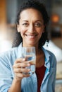 Hydrate to feel great. Portrait of a woman drinking a glass of water at home. Royalty Free Stock Photo