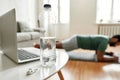 Hydration is important. Close up shot of water bottle, laptop and wireless earbuds on the table. Young active man