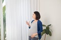 Hydration. Positive Pregnant Girl Drinking Water From Glass Standing Looking In Window Indoor