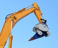 Hydraulic detail of crane arm and demolition element against blue sky