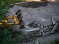 Hydraulic Excavator Removing Remains of asphalt. Road reconstruction. Pavement repair