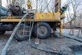 Hydraulic ground water hole drilling machine installed on the old truck with big wheels on the construction site. Groundwater well