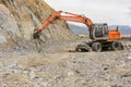 Hydraulic hammer grinding rock and stone at road construction works Royalty Free Stock Photo