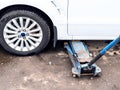 Hydraulic jack lifts a vehicle outdoors
