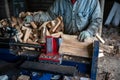 Hydraulic log splitter blade cuts into wood with workman and woodpile Royalty Free Stock Photo