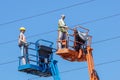 Hydraulic mobile construction platform elevated towards a blue sky with false construction workers . dummy man Royalty Free Stock Photo