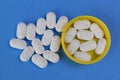 Hydrocodone tablets in a yellow cap against a blue background. Opiate addiction costs the U.S. economy $78.5 billion per year