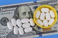 Hydrocodone tablets in a yellow cap against a hundred dollar bill. Opiate addiction costs the U.S. economy $78.5 billion per year