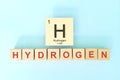 Hydrogen chemical element symbol with atomic mass and atomic number in wooden blocks flat lay composition.