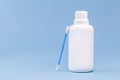 Hydrogen peroxide, in white plastic bottle, with cotton swab and isolated blue background, medicine concept, medicine for wounds Royalty Free Stock Photo