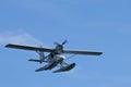Hydroplane seaplane or floatplane flying in blue sky closeup. Cabin, wings propeller, engine, tail of plane are visible in detai
