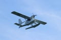 Hydroplane seaplane or floatplane flying in blue sky closeup. Cabin, wings propeller, engine, tail of plane are visible in detai