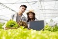 Hydroponics, a smiling young Asian farmer holding a vegetable basket and blackboard, stands on a farm growing commercial organic Royalty Free Stock Photo