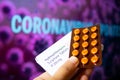 Hydroxychloroquine Sulphate tablets with coronavirus written in background