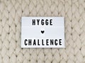 HYGGE CHALLENGE word on lightbox on knit background. Cozy compozition. Knit background. Royalty Free Stock Photo