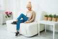 Hygge, comfort and home concept, Young woman in warm beige hand knitted hat. Royalty Free Stock Photo