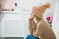 Hygge, comfort and home concept, Young woman in warm beige hand knitted hat. Royalty Free Stock Photo