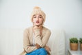 Hygge, comfort and home concept, Young woman in warm beige hand knitted hat. Royalty Free Stock Photo