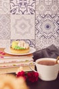 Hygge home aesthetic. Floral french tart with flowers. Ceramic tile background. Pink floral cake and coffee, guilty