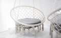 Hygge scene with white hammock chair with grey pillow on white background. Cozy home interior